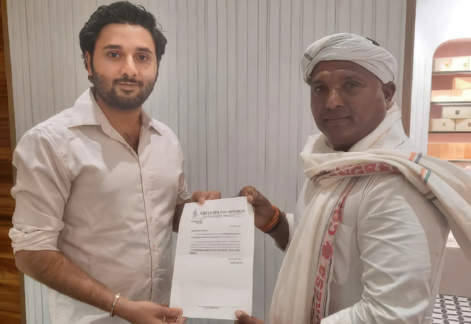 Salmaan Ahmed handing over a certificate to an elderly community member