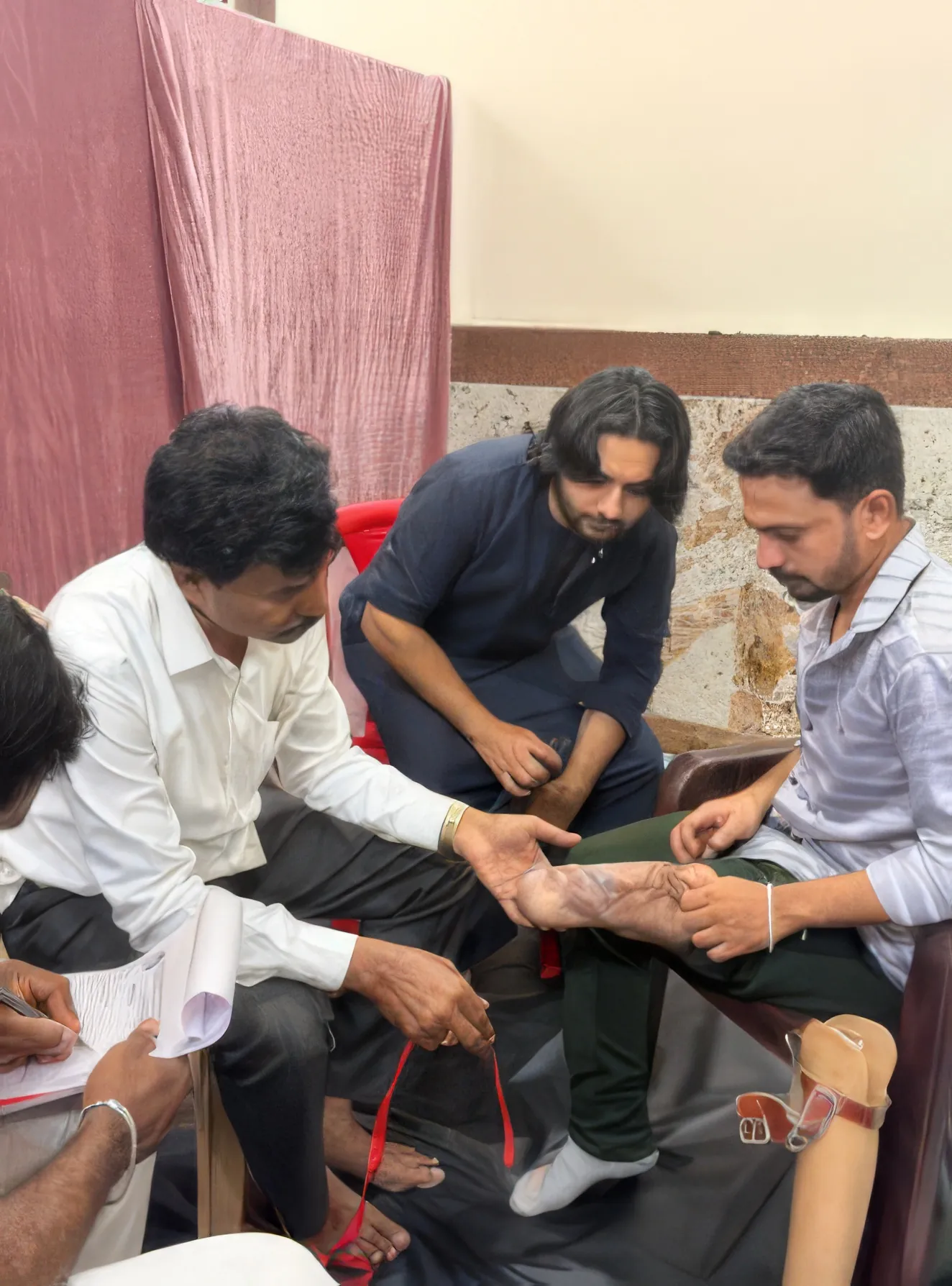 A beneficiary being fitted with a prosthetic limb at a health camp